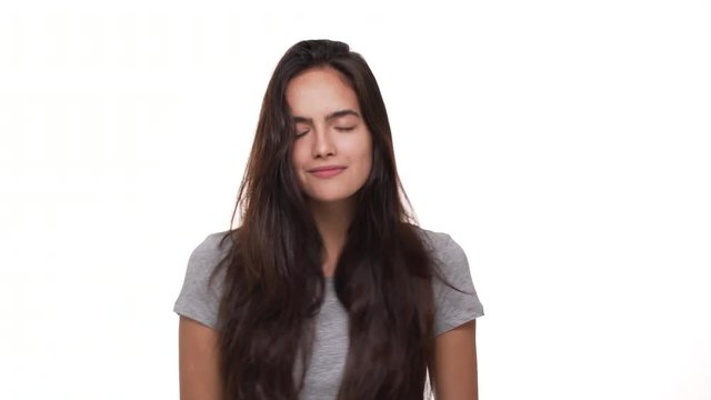 portrait of sexy brunette womanl with long dark hair dancing on camera with closed eyes smiling touching hair isolated over white background closeup. Concept of emotions