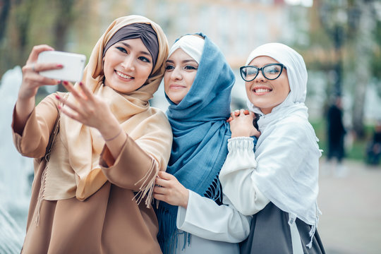 Three muslim woman laughing and making selfie together