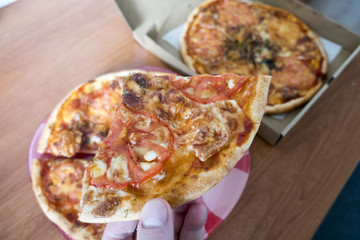 a slice of pizza in his hand