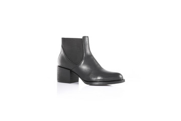 Close up of a women's black leather chelsea boots on white background with reflection. Fashion...