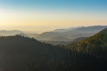 Autumn landscape - Black Forest. Panoramic view over the autumnal Black Forest, the Rhine valley and the Vosges (France) in the distance at sunset.