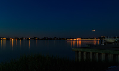 Obraz premium Dock, boat and marshes at sunset and blue hour off New Jersey inlet.