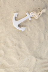 Fototapeta na wymiar A white anchor in the sand on the beach