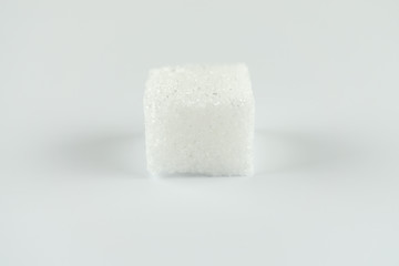 One sugar cube on white background