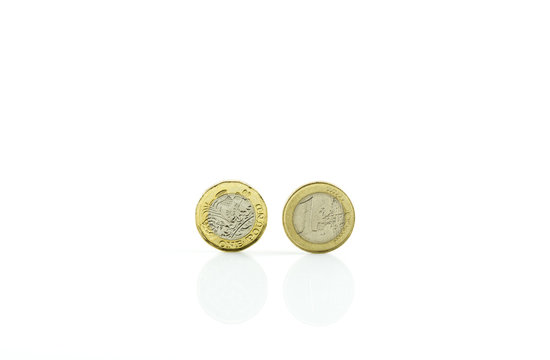 One euro coin and a pound of coin isolated on white