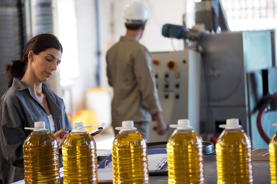 Female worker maintaining record while technician operating