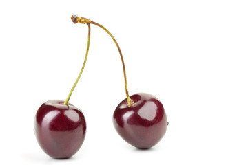 ripe juicy cherry berries with leaves on a white table