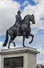 Fototapeta na wymiar PARIS - Henrici Magni bronze equestrian statue near Pont Neuf. Representing the King of France Henri IV in armor, crowned with laurel and a scepter in his hand.