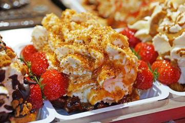 The Belgian wafer. Delicious Belgian waffle with cream, fruit and sauce looks beautiful in the window of the Brussels confectionery store.