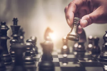 Tuinposter Businessman moving chess piece on chess board game concept for ideas and competition and strategy, business success concept, business competition planing teamwork strategic concept. © totojang1977