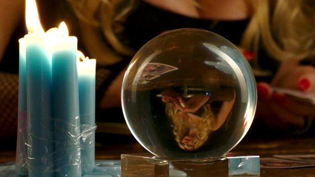 The portrait of the predictor of the future is reflected in the crystalline ball. Close up portrait. 