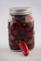 Close up of red olives with jalapeno in container