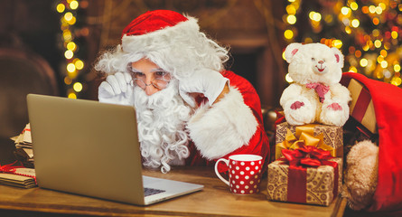 Santa Claus with  computer before christmas