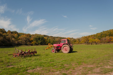 tractor at meadow in beauty autumn landscape, agricultural scene