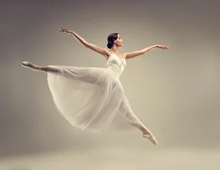 Photo sur Aluminium École de danse Ballerina. Young graceful woman ballet dancer, dressed in professional outfit, shoes and white weightless skirt is demonstrating dancing skill. Beauty of classic ballet.