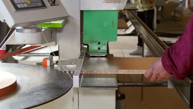 Automatic edge banding machine at a furniture factory