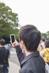 スマートフォンで写真を撮る男性