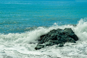 Big waves breaking on the shore with sea foam