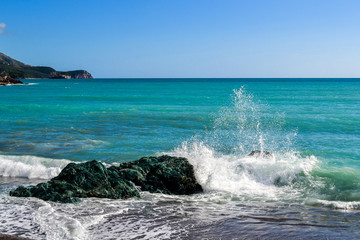 Big waves breaking on the shore with sea foam