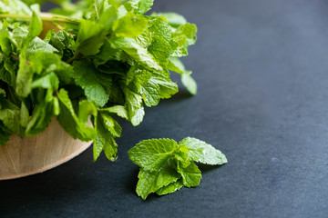 mint leaf. Green fresh mint, selective focus. Bunch of Fresh green organic mint leaf closeup. Peppermint. Natural light. Selective focus. Close up on a black background. Top view, flat lay. copy space © yavdat