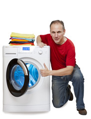happy man shows a thumb near new washing machine..