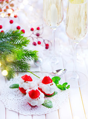 Obraz na płótnie Canvas Christmas holiday dessert. Strawberry Santa stuffed with whipped cream. Funny Xmas party food idea