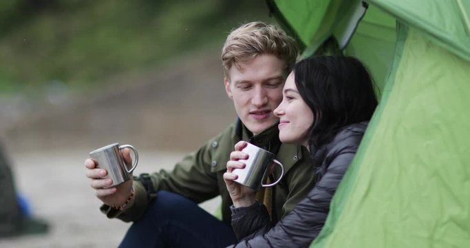 Young couple camping on the beach in fall
