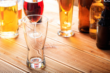 A wooden pub counter, focus on an empty glass of beer