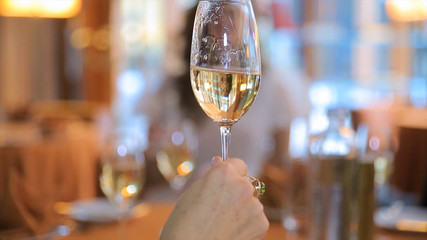 Woman drinks a glass of champagne and cheers. Woman cheers with a glass of champagne. Holding a Glass of Champagne
