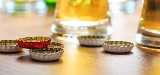 Beer caps and glasses of beer on a pub background