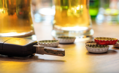Drinking and driving. Car key on a wooden bar counter