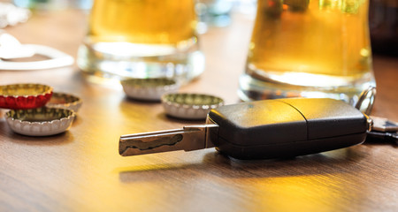 Drinking and driving. Car key on a wooden bar counter