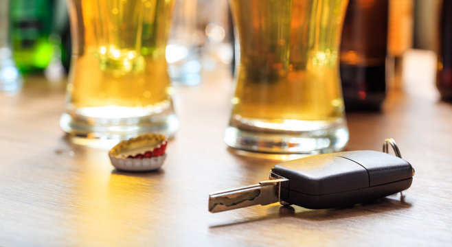 Drinking and driving. Car key on a wooden bar counter
