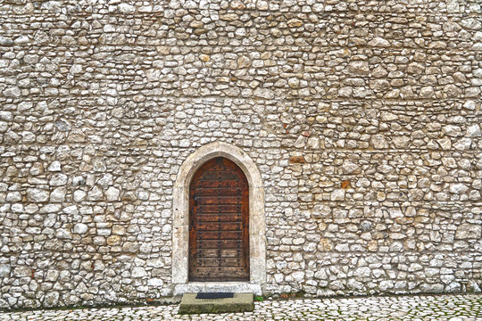 Fortress stone wall with a wooden door