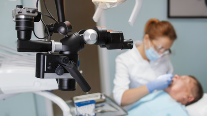 modern microscope with camera and dentist at work