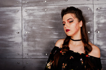 Close up studio portrait of black girl in dress with bright make-up. Halloween theme.