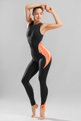 Fototapeta premium Slender Caucasian girl in stylish cuddly clothes for fitness and aerobics. Studio portrait of a sports girl.