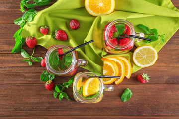 Composition with mason jars of infused water on wooden table
