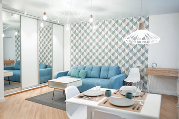 Interior of modern apartment with table served for dinner