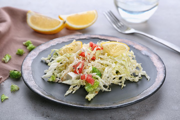 Plate with tasty vegetable salad on table