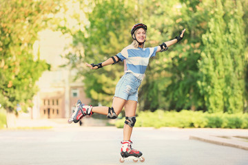 Young woman on roller skates in summer park