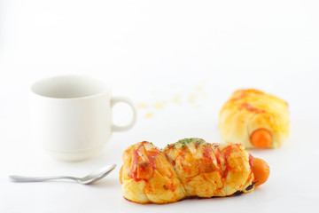 bread with sausage , a cup of coffee and spoon