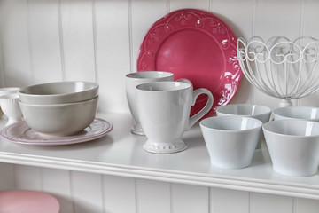 White storage stand with dishware in kitchen