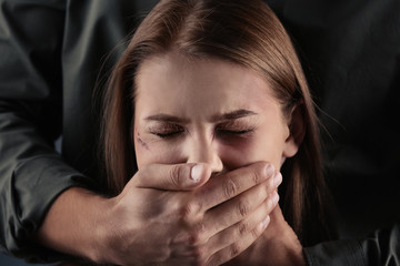 Man covering young woman's mouth
