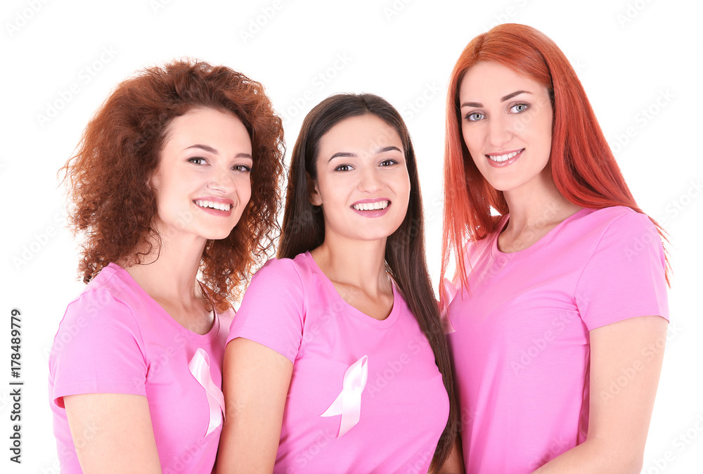 Wall mural Young women in pink t-shirts on white background. Breast cancer awareness concept