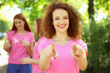 Young woman in pink t-shirt outdoors. Breast cancer awareness concept