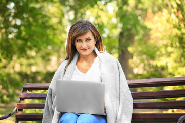 Mature woman using laptop outdoors