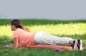 Mature woman doing exercises in park