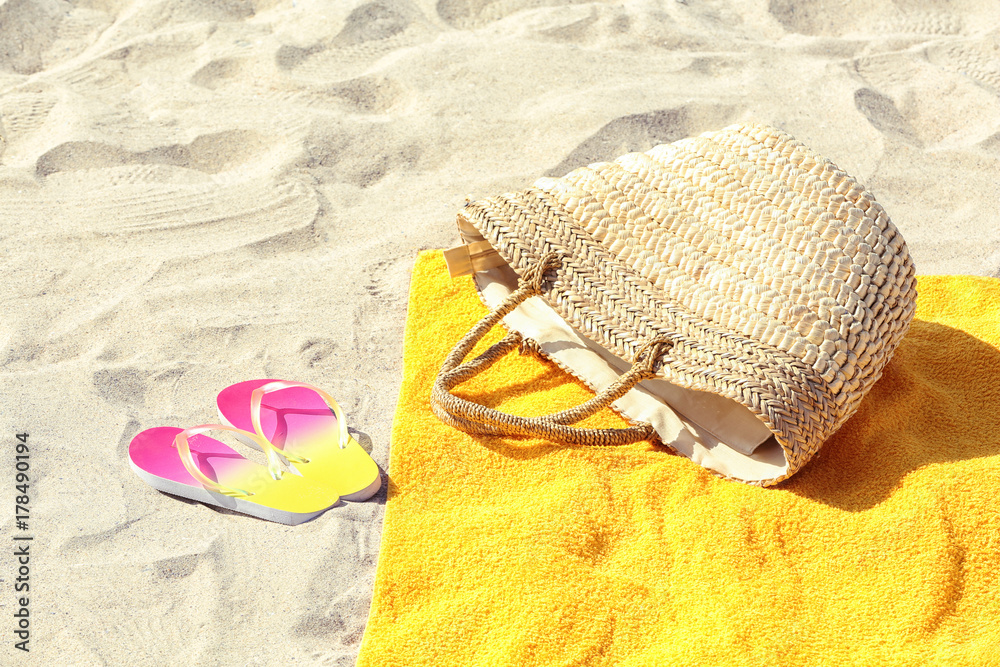 Poster Yellow beach towel, with bag and flip flops on sand