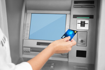 Woman inserting credit card into cash machine, closeup
